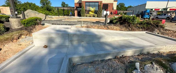 A newly poured concrete slab at a commercial building site, showcasing smooth and even surfaces.